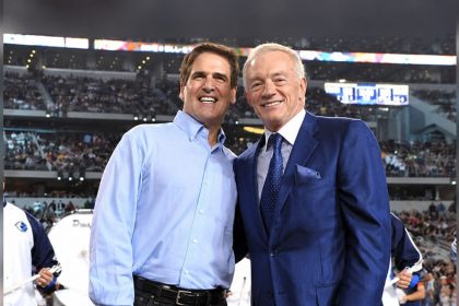 Mark Cuban and Jerry Jones smiling together at a sports stadium before an event.