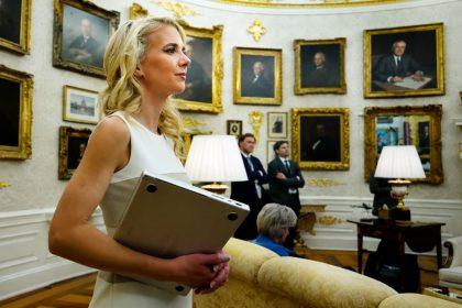 Natalie Harp holding a laptop in an ornate room