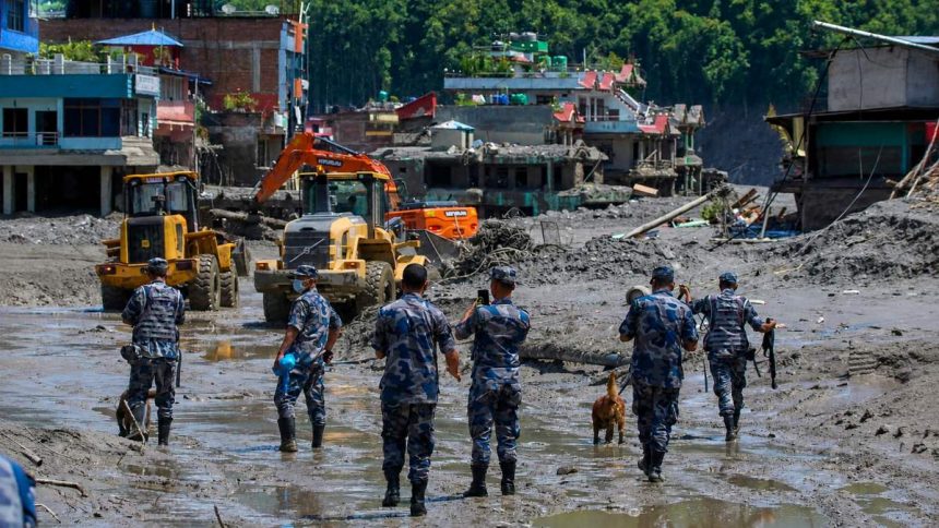 Police watch earthmovers clear debris in Nepal’s Nuwakot district