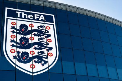 The FA crest on a blue glass building exterior