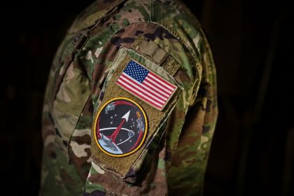 U.S. military uniform with American flag and space mission patch.