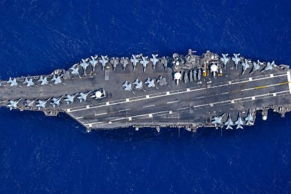 USS Abraham Lincoln aircraft carrier with fighter jets at sea.