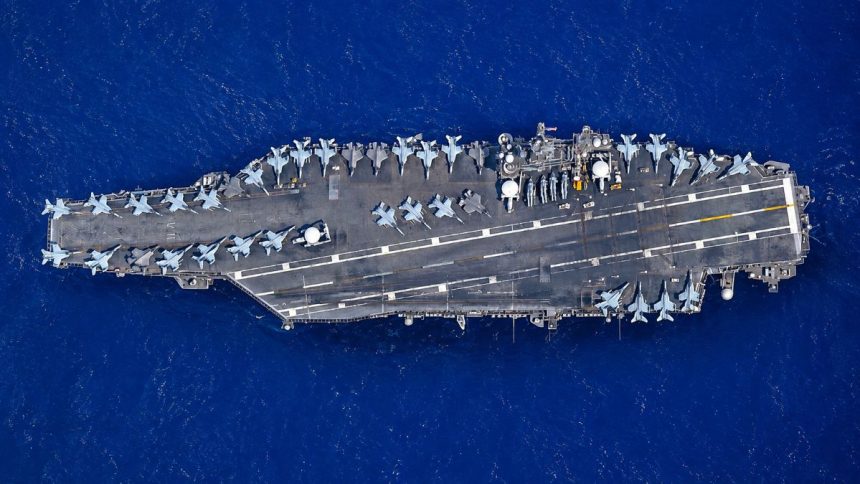 USS Abraham Lincoln aircraft carrier with fighter jets at sea.