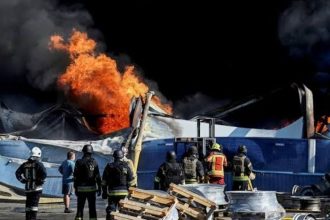 Firefighters work at a site hit by a Russian drone strike in Kyiv.