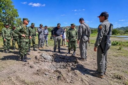 Colombian soldiers inspect a crater after a reported drone attack