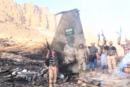 Houthi fighters beside claimed wreckage of a Saudi F-15 in Yemen.