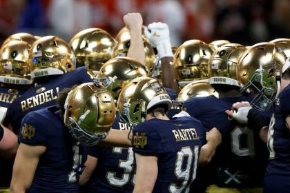 Notre Dame Fighting Irish football players in a huddle.