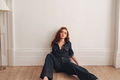 W Magazine photo of Sadie Sink seated on the floor in a dark denim jumpsuit.