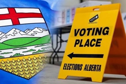Alberta flag beside a yellow Elections Alberta voting-place sign pointing toward a polling station.