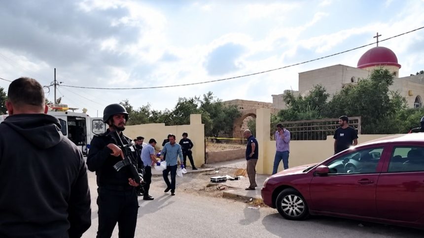 Security personnel and investigators at the scene outside Saint George’s Greek Orthodox Church in Jordan following a reported attack.