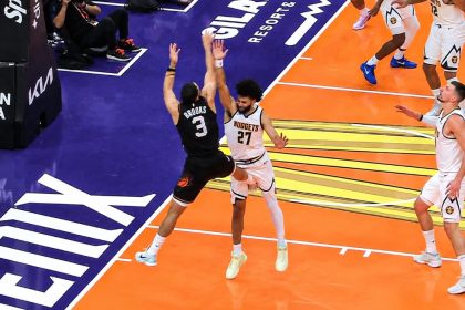 Dillon Brooks of the Phoenix Suns attempts a jump shot as Denver Nuggets defender No. 27 contests him.