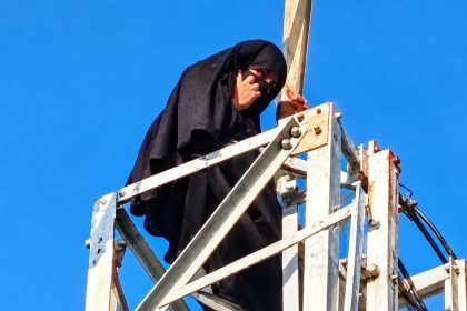 Woman in a black veil perched on a 100-foot mobile tower in Uttar Pradesh amid reports of her attempt to marry her partner.