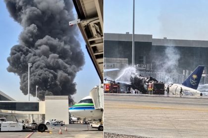 Thick black smoke rises near an airport terminal as emergency crews respond to a damaged aircraft on the runway.