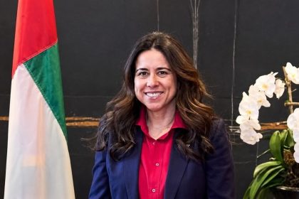 Senior Arab diplomat Lana Nusseibeh wearing a navy blazer and red blouse.