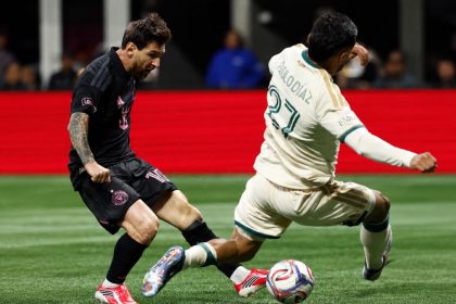 Lionel Messi in Inter Miami’s black kit challenges for the ball against Atlanta United during an MLS match.
