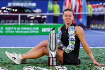Maja Chwalińska sits on the court beside the Wuhan Open trophy after winning the title.