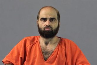 Former Army psychiatrist Nidal Malik Hasan wearing an orange prison uniform.