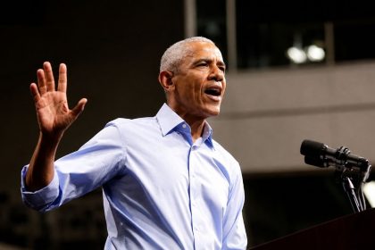 Former US President Barack Obama speaking at a Democratic campaign rally at a podium.