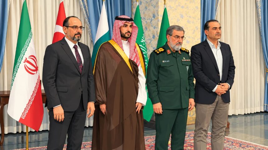 Officials standing alongside Iranian and Saudi flags during a diplomatic meeting. Image: Anadolu Agency