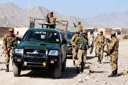 Pakistan Army personnel in camouflage uniforms stand beside a green military vehicle in Qila Saifullah, Balochistan.