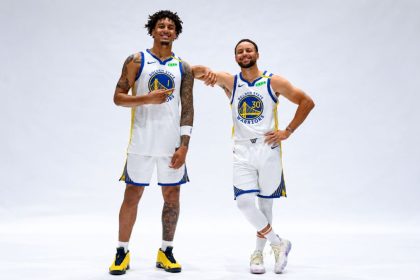 Golden State Warriors rookie Yaxel Lendeborg and Stephen Curry posing together in white Warriors jerseys.